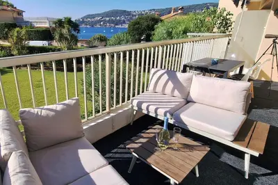 a balcony with two couches and a coffee table at La Suite de Saint-Jean-Cap-Ferrat, vue mer et accès mer in Saint-Jean-Cap-Ferrat