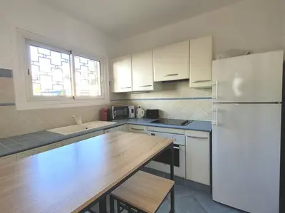 a kitchen with white cabinets and a wooden counter top at La Suite de Saint-Jean-Cap-Ferrat, vue mer et accès mer in Saint-Jean-Cap-Ferrat