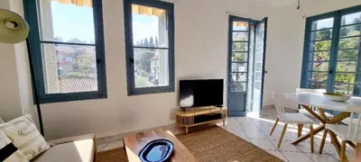a living room with a tv and a table and windows at Bright Appartment perfect location in Saint-Jean-Cap-Ferrat