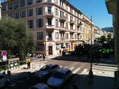 a city street with cars parked in front of a building at Appartement Nice Centre Medecin in Nice