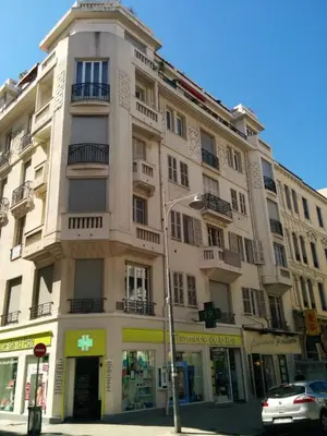 a tall building on a street with a car in front at Appartement Nice Centre Medecin in Nice