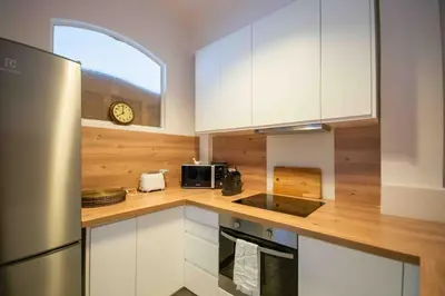 a kitchen with white cabinets and a stainless steel refrigerator at Sublime 4 pièces quartier des Musiciens in Nice