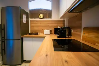 a kitchen with a refrigerator and a clock on the wall at Sublime 4 pièces quartier des Musiciens in Nice