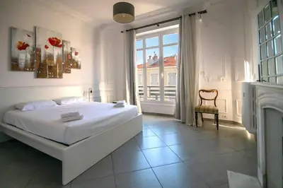 a white bedroom with a bed and a fireplace at Sublime 4 pièces quartier des Musiciens in Nice