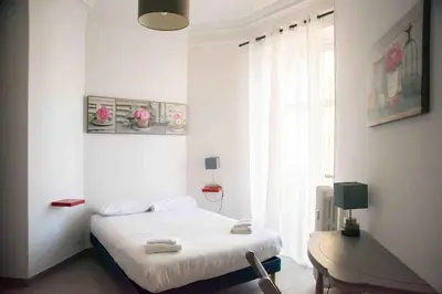 a bedroom with a bed and a desk and a window at Sublime 4 pièces quartier des Musiciens in Nice