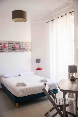a white bedroom with a bed and a table and a tableablish at Sublime 4 pièces quartier des Musiciens in Nice