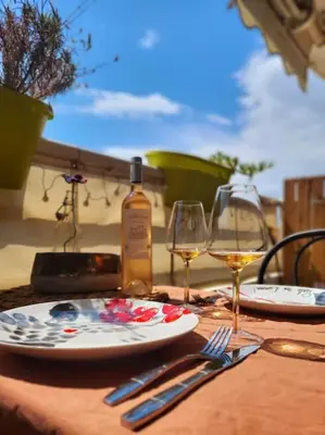 a table with two glasses and a bottle of wine at Une invitation à la détente in Nice