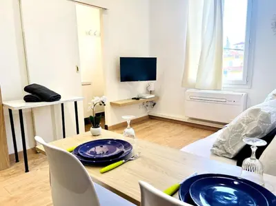 a living room with a table with a blue plate on it at LE RAPHAEL - Studio à 10 min de la mer - Wifi et Climatisation in Nice