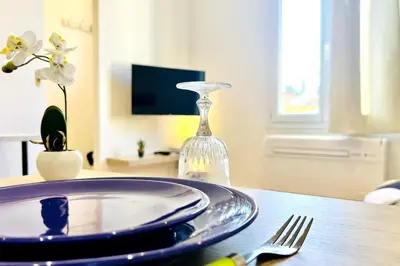 a table with a plate and a glass bottle on it at LE RAPHAEL - Studio à 10 min de la mer - Wifi et Climatisation in Nice