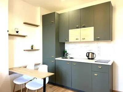 a kitchen with blue cabinets and a wooden table at LE RAPHAEL - Studio à 10 min de la mer - Wifi et Climatisation in Nice