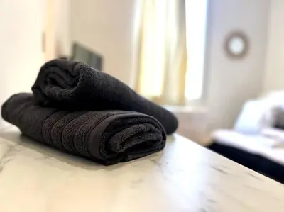 a stack of towels sitting on top of a table at LE RAPHAEL - Studio à 10 min de la mer - Wifi et Climatisation in Nice