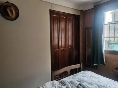 a bedroom with a bed and a wooden cabinet at Maison traditionnelle sur les collines Niçoises in Nice