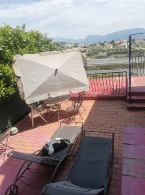 a cat laying on a chair on a patio at Maison traditionnelle sur les collines Niçoises in Nice
