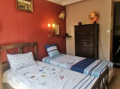 a bedroom with two twin beds and a dresser at Maison traditionnelle sur les collines Niçoises in Nice