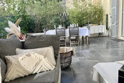 a patio with a couch and a table and chairs at Superbe Appartement de 105 m2, hyper centre avec Terrasse, parking, à 5 min de la mer in Nice