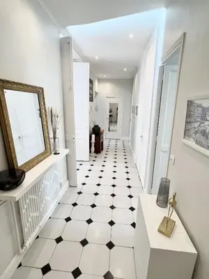 a white hallway with a black and white tiled floor at Superbe Appartement de 105 m2, hyper centre avec Terrasse, parking, à 5 min de la mer in Nice