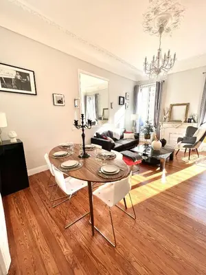 a living room with a table and a couch at Superbe Appartement de 105 m2, hyper centre avec Terrasse, parking, à 5 min de la mer in Nice