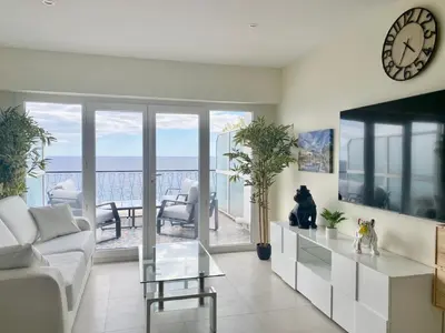 a living room with a couch and a clock on the wall at SEA FRONT View Top Roof Flat in Nice