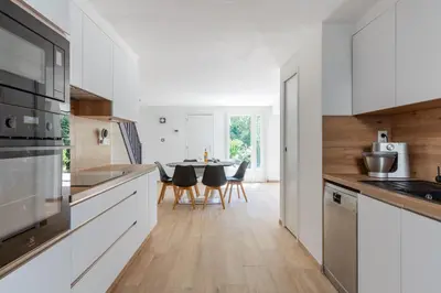 a kitchen with white cabinets and a table with chairs at Villa Summertime in Nice
