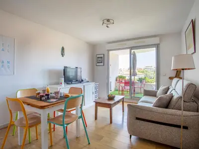 a living room with a couch and a table with chairs at Apartment Le Lagon Bleu by Interhome in Cagnes-sur-Mer