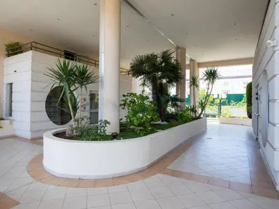 a hallway with palm trees in a building at Apartment Le Lagon Bleu by Interhome in Cagnes-sur-Mer
