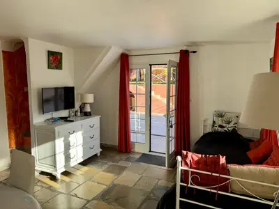 a bedroom with a bed and a tv and a window at Chambre d'hôtes duplex Le petit mas niçois de la Villa rose in Nice