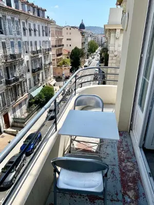 a table and chairs on a balcony with a view of a city at Central Rossini Flat with Balcony in Nice