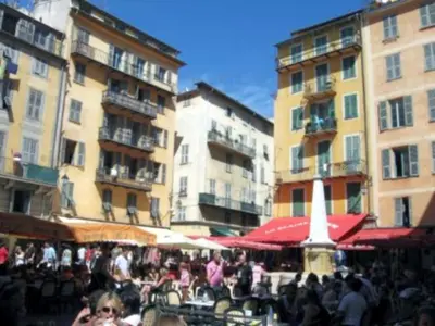 a group of people sitting at tables in front of buildings at Studio Climatisé dans villa bourgeoise in Nice