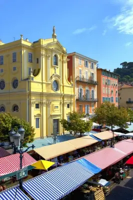 a large yellow building with a clock on it at Studio Climatisé dans villa bourgeoise in Nice