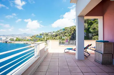 a balcony with chairs and a view of the water at LE CAP DE NICE VI4150 by RIVIERA HOLIDAY HOMES in Nice
