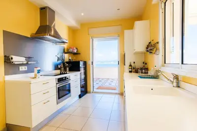 a kitchen with white appliances and a large window at LE CAP DE NICE VI4150 by RIVIERA HOLIDAY HOMES in Nice