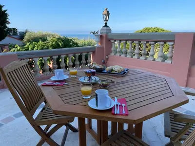 a wooden table with food and drinks on a balcony at Chambre d'hôtes A l'ancre marine de la Villa Rose in Nice