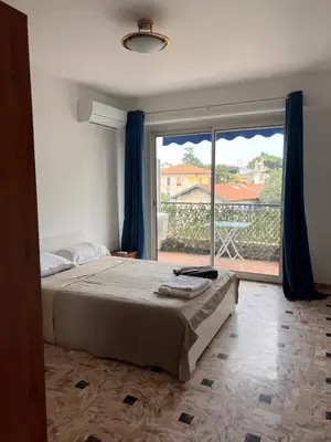 a bedroom with a bed and a large window at Grand appartement proche Promenade in Nice