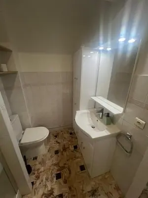 a white bathroom with a toilet and a sink at Grand appartement proche Promenade in Nice