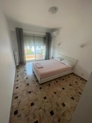 a bedroom with a bed and a large window at Grand appartement proche Promenade in Nice