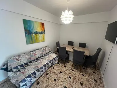 a room with a table and chairs and a couch at Grand appartement proche Promenade in Nice