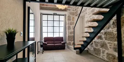 a living room with a staircase and a chair at Très joli loft au cœur de Nice in Nice
