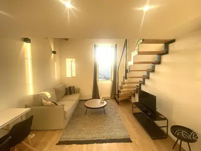 a living room with stairs and a couch and a table at Lamartine hypercentre 503 in Nice