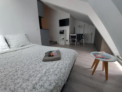 a bedroom with a bed and a table and a staircase at Centre de Nice : Studio rénové, climatisé et calme in Nice
