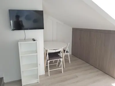 a room with a table and a tv on a wall at Centre de Nice : Studio rénové, climatisé et calme in Nice