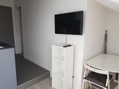 a living room with a tv on a white wall at Centre de Nice : Studio rénové, climatisé et calme in Nice
