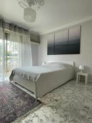 a bedroom with a large bed and a large window at Grand 2 pièces à 4mns de la plage in Cagnes-sur-Mer
