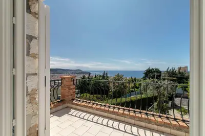 a door to a balcony with a view of the ocean at Maison Bianchi - Villa Saint Pierre de Feric in Nice