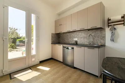 a kitchen with white cabinets and a large window at Maison Bianchi - Villa Saint Pierre de Feric in Nice