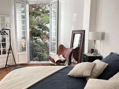 a bedroom with a bed and a chair and windows at Luxueux Appartement 115m2, 3 Chambres centre ville avec parking à 5 min plage -climatisation in Nice