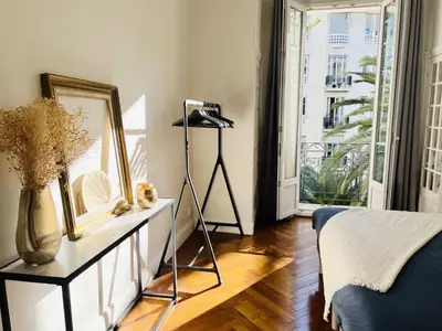 a bedroom with a dresser with a mirror and a window at Luxueux Appartement 115m2, 3 Chambres centre ville avec parking à 5 min plage -climatisation in Nice