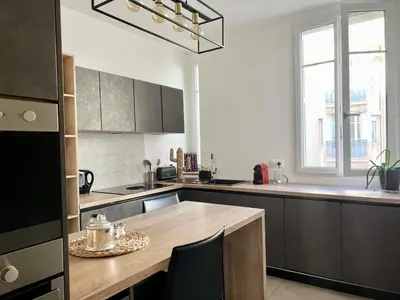 a kitchen with a wooden table and a large window at Luxueux Appartement 115m2, 3 Chambres centre ville avec parking à 5 min plage -climatisation in Nice