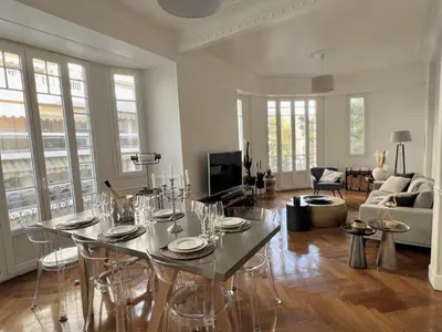 a living room with a table and chairs in it at Luxueux Appartement 115m2, 3 Chambres centre ville avec parking à 5 min plage -climatisation in Nice