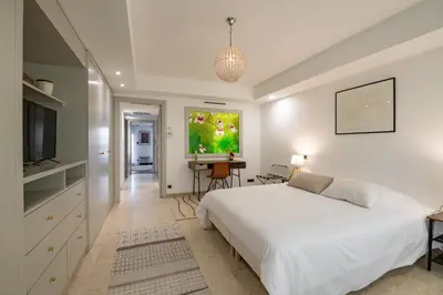 a bedroom with a white bed and a flat screen tv at Chauvain Résidence in Nice