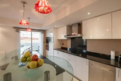 a kitchen with a glass table with fruit on it at Chauvain Résidence in Nice